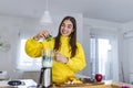 Beautiful woman making fruits smoothies with blender. Healthy eating lifestyle concept. Young woman preparing drink with bananas,