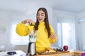 Beautiful woman making fruits smoothies with blender. Healthy eating lifestyle concept. Young woman preparing drink with bananas,