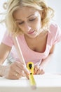 Beautiful woman marking table with measure tape Royalty Free Stock Photo