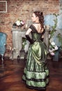 Beautiful woman in medieval dress near fireplace