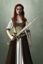 Beautiful woman in a medieval fantasy dress holding a sword