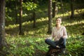 Beautiful woman meditating in the forest on a sunny morning Royalty Free Stock Photo