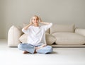 Beautiful woman meloman with very short hair listens to music near couch