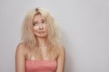 Beautiful woman with messed up hair. Unhappy grimacing face. Blond bleaching hairstyle with problem brittle hair Royalty Free Stock Photo