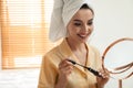 Beautiful woman with mirror applying makeup Royalty Free Stock Photo