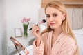 Beautiful woman with mirror applying makeup Royalty Free Stock Photo