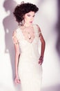 Beautiful woman model posing in elegant pearl dress in the studio