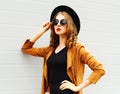 Beautiful woman model wearing a black hat, sunglasses and jacket Royalty Free Stock Photo