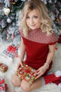 Beautiful woman near a Christmas tree with a cup of coffee with marshmallows Royalty Free Stock Photo