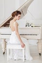 Beautiful woman near the white piano