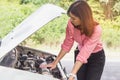 Beautiful woman need help. Woman trying to fix car engine on the road