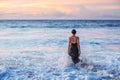 Beautiful woman by the ocean at sunset