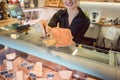 Beautiful woman offering cheese on delicatessen counter Royalty Free Stock Photo