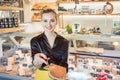 Beautiful woman offering cheese on delicatessen counter