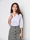 Beautiful woman office manager posing in a new casual white blouse and classic straight dark skirt