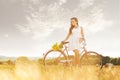 Beautiful woman with old bike in a wheat field Royalty Free Stock Photo