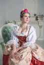 Beautiful woman in old-fashioned medieval dress on the sofa