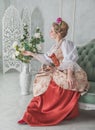 Beautiful woman in old-fashioned medieval dress on the sofa
