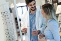 Beautiful woman with optician trying eyeglasses