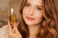 Beautiful woman with organic oil serum bottle, evening beauty and skincare routine