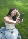 Beautiful woman outdoor young woman resting in city park and take a selfie photo Royalty Free Stock Photo