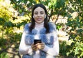 Beautiful woman outdoors, has a wireless earphones in her ears. Hand phone Royalty Free Stock Photo