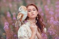 Beautiful woman with owl at her shoulder of pink flowers