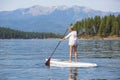 Beautiful woman paddleboarding on scenic mountain lake Royalty Free Stock Photo