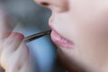 Beautiful woman paints lips with lipstick. Beautiful woman face.