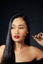 Beautiful woman paints lips with lipstick. Beautiful woman face. Makeup detail. Beauty girl with perfect skin. Red lips and nails