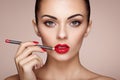 Beautiful woman paints lips with lipstick Royalty Free Stock Photo