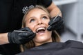 Beautiful woman patient having dental treatment at dentist`s office. Woman visiting her dentist