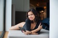 Beautiful woman with perfect body in black bodysuit lying on mattress near big window on vacation Royalty Free Stock Photo