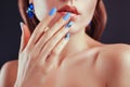 Beautiful woman with perfect make-up and blue manicure wearing jewellery. Nail design. Beauty and fashion concept. Royalty Free Stock Photo