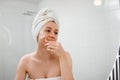 Beautiful woman with perfect skin wearing white towel after shower, making face massage using a jade face roller with natural Royalty Free Stock Photo