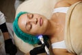 Beautiful woman perform facial massage with microcurrents