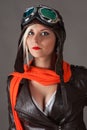 Beautiful woman pilot in red scarf in aviator helmet