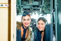 Beautiful woman pilot wearing uniform. Happy and successful flight. Looking at camera in plane. Girls looking at camera Royalty Free Stock Photo