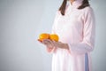 Beautiful woman in pink dress and vietnam hat holding orange