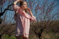 Beautiful blonde woman in pink dress walks through the flowering garden Royalty Free Stock Photo