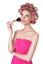 Beautiful woman with pink hair curlers holding makeup brush Royalty Free Stock Photo