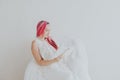 Beautiful woman with pink hair reading a book in a white room Royalty Free Stock Photo