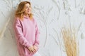 Beautiful woman in a pink hoodie posing against a white wall background. Royalty Free Stock Photo