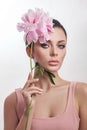 Beautiful woman with pink peony flowers, natural beauty, skin care. Perfect facial features. Girl posing on a light background Royalty Free Stock Photo