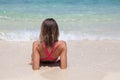 Beautiful woman in a pink swimsuit lies on white sand beach Royalty Free Stock Photo