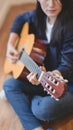 Beautiful woman playing acoustic guitar in comfortable room Royalty Free Stock Photo