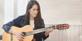 Beautiful woman playing acoustic guitar in her free time at home Royalty Free Stock Photo