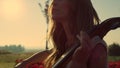 Woman playing cello in summer park in sunshine. Young artist rehearsing outdoors Royalty Free Stock Photo