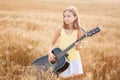 beautiful woman playing gitar on the field Royalty Free Stock Photo