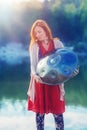 beautiful woman playing with hangdrum in nature. Royalty Free Stock Photo